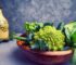 a wooden bowl filled with broccoli and other vegetables