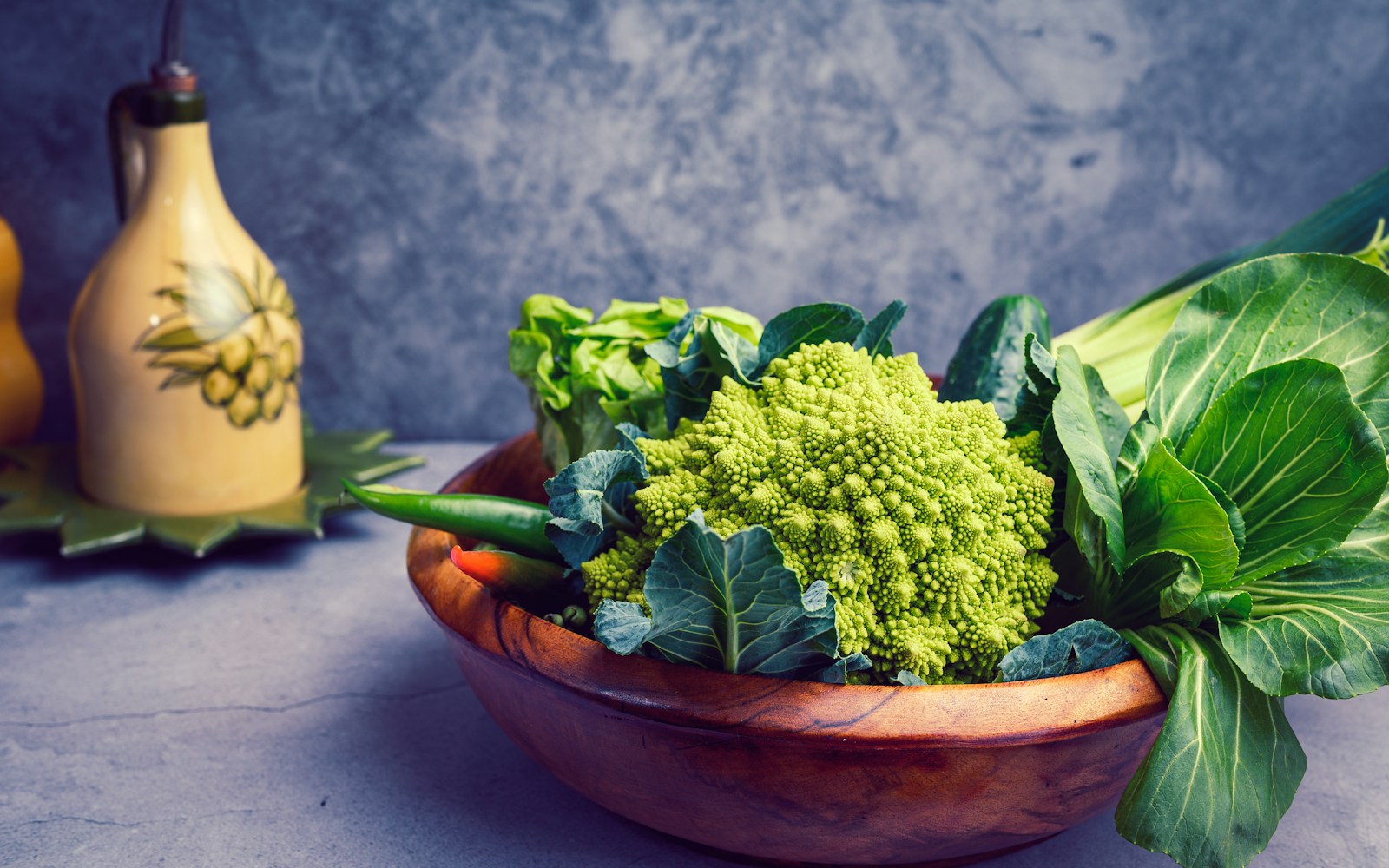 a wooden bowl filled with broccoli and other vegetables