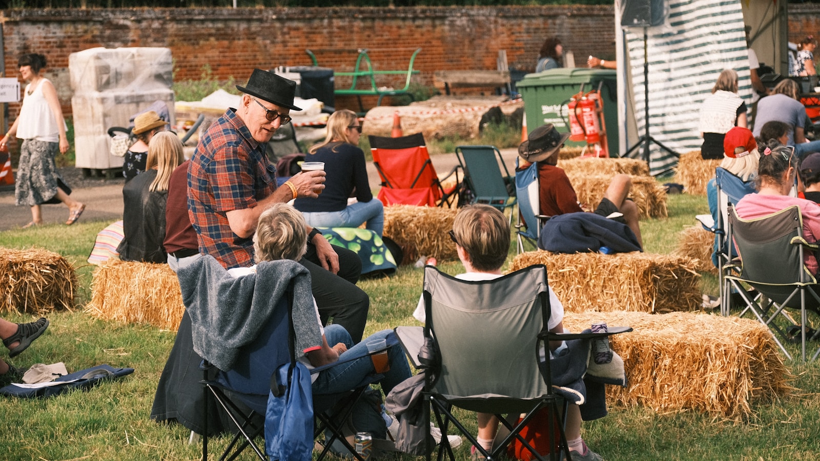 a group of people sitting on top of a lush green field